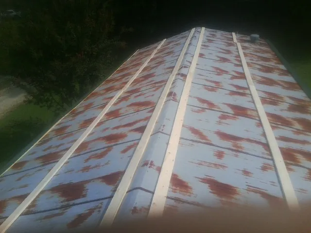 Rusted metal roof panels with new wood purlins before replacement — Storm Damage Roof Repair in Morganton by Roofing Brothers
