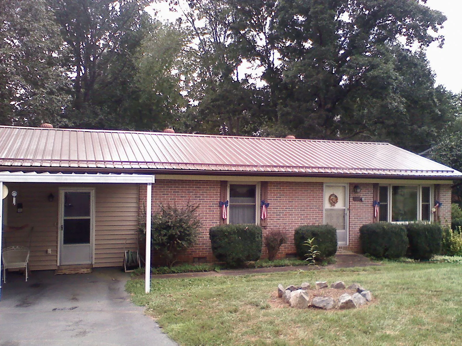 Bronze metal roof and carport on a brick ranch home — Roof Repair work by our crew in Morganton