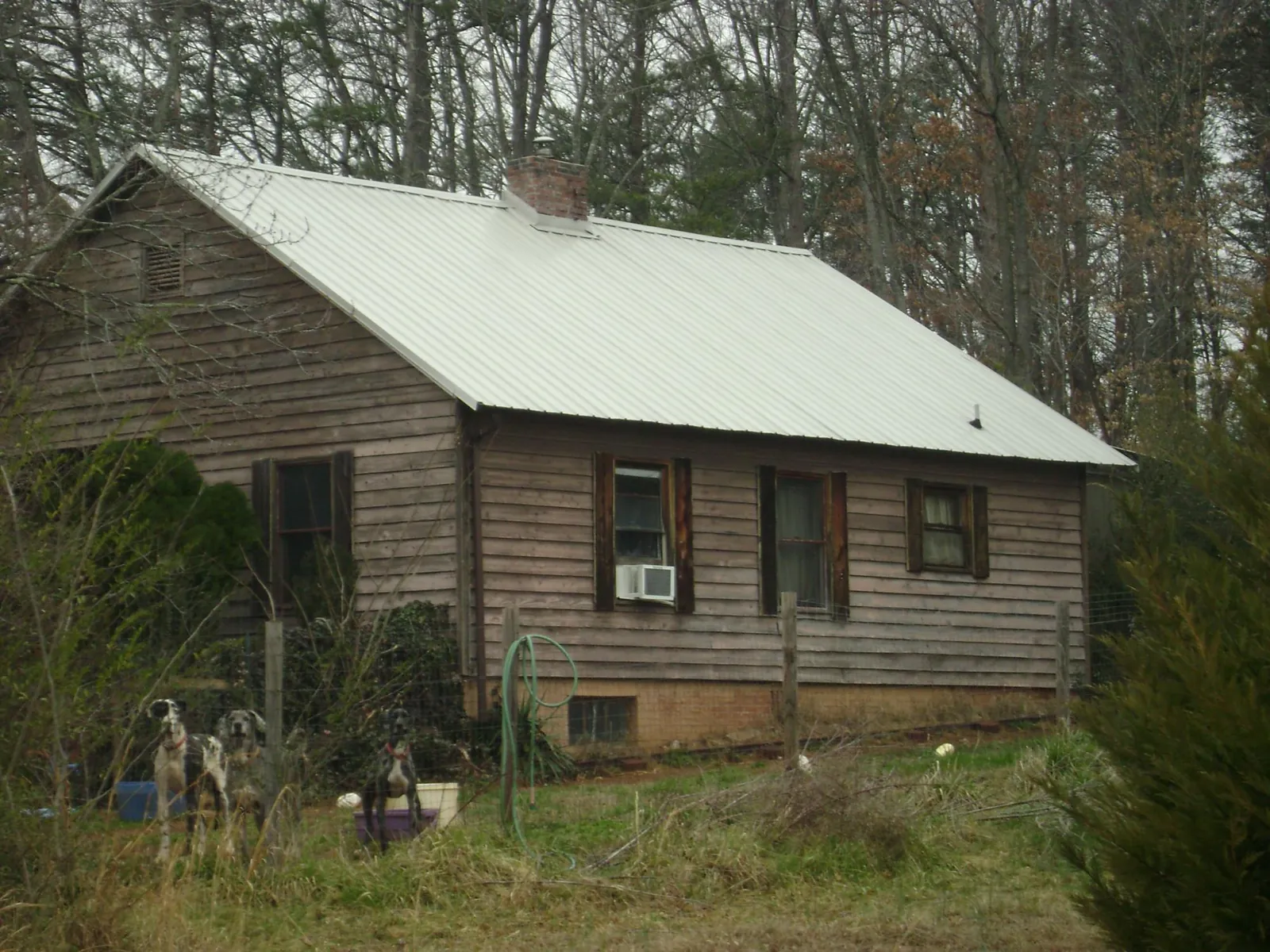 White metal roof on an old wood sided farmhouse, from a Metal Roof Installation job in Morganton